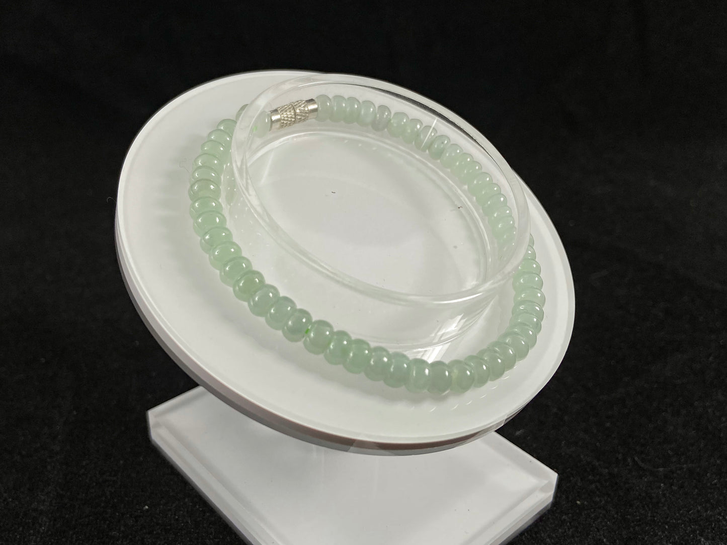 A strand of translucent light green oval jade beads.