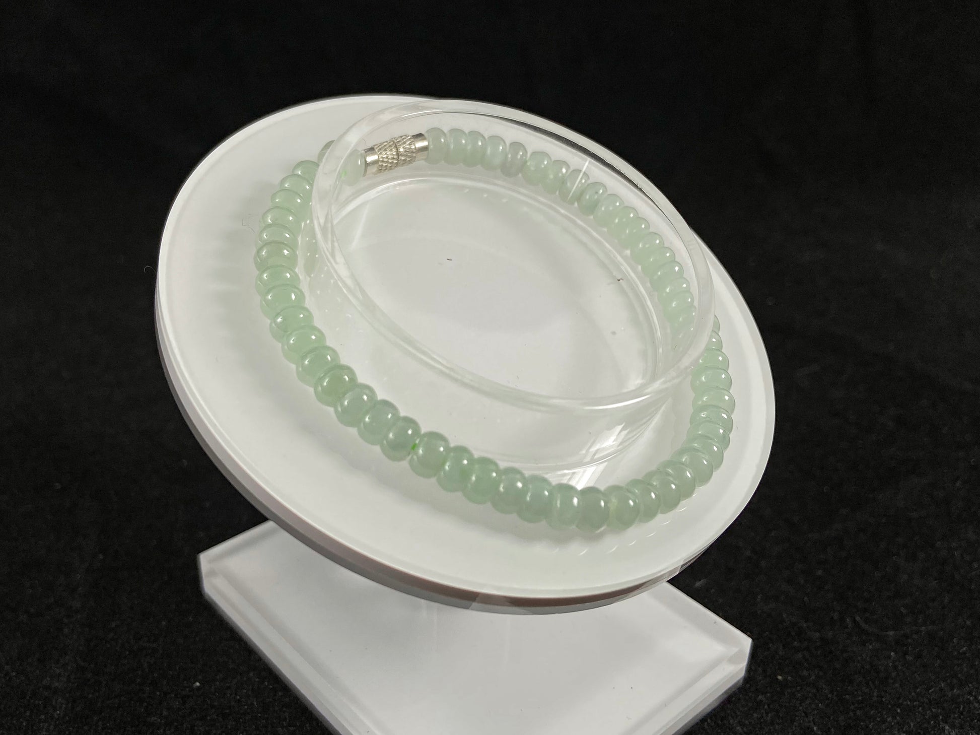 A strand of translucent light green oval jade beads.