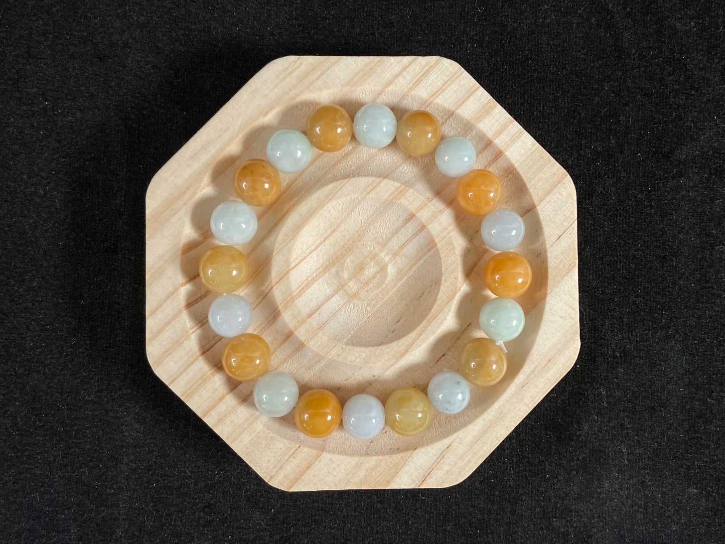 A jade bead strand with alternating creamy white and yellow/brown beads.
