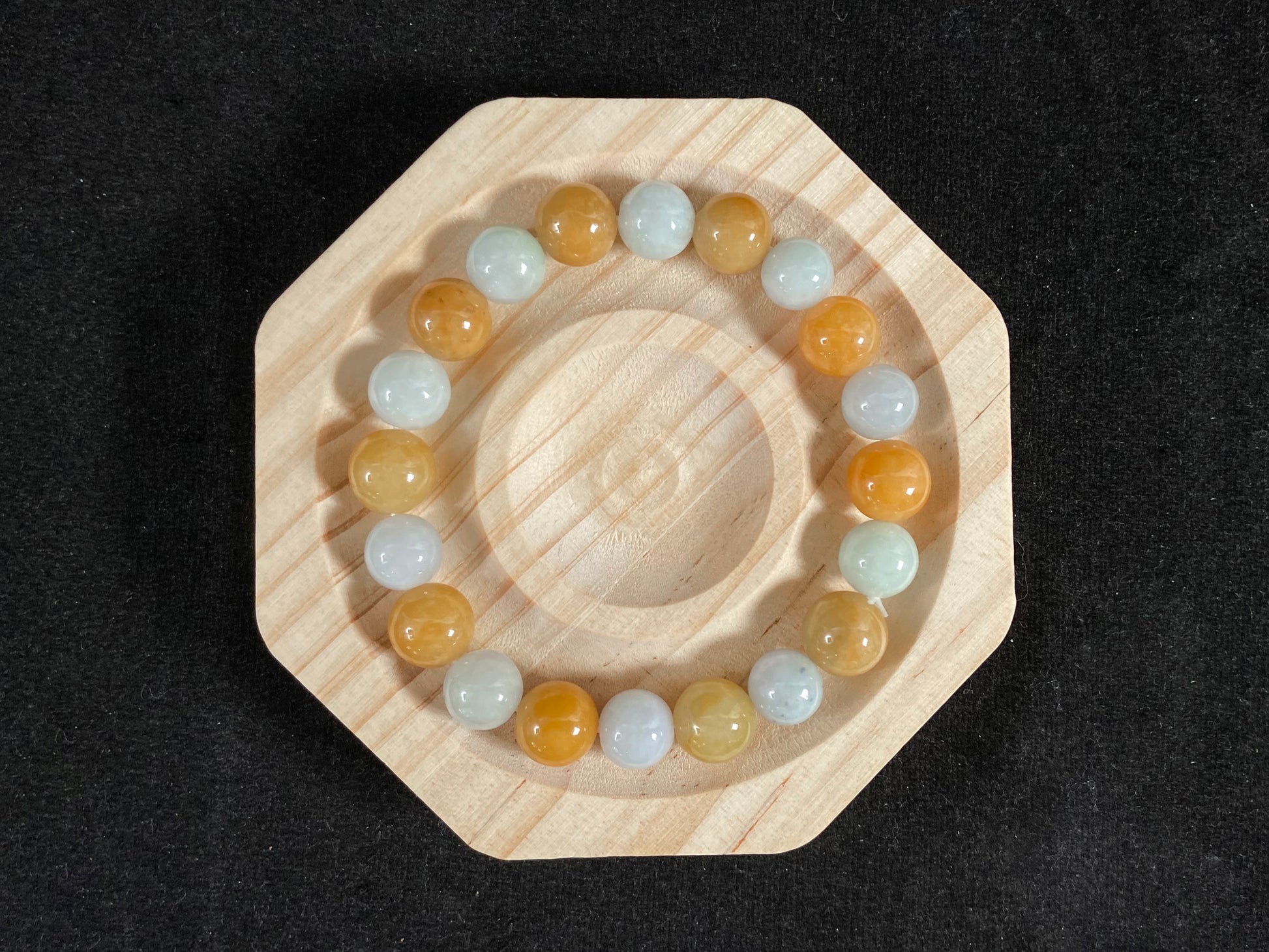 A jade bead strand with alternating creamy white and yellow/brown beads.