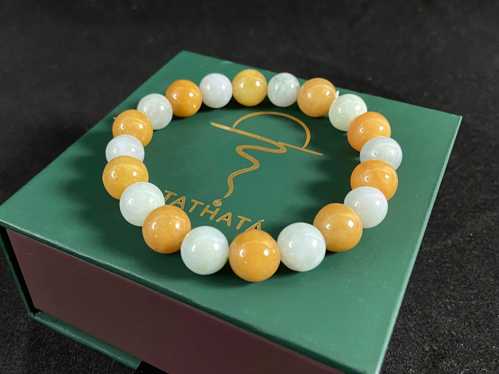 A jade bead strand with alternating creamy white and yellow/brown beads.