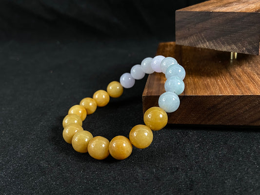 A jade strand with yellow beads and white beads softly blended with pink, green, and gray.