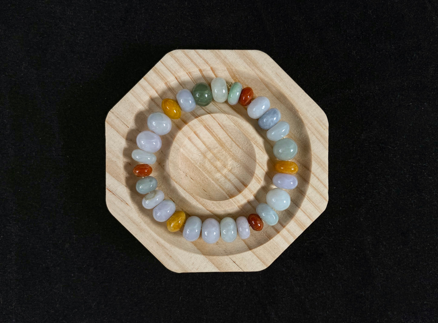 A strand of irregular abacus-shaped jade beads in creamy white, forest green, reddish brown, yellow, tan and light green.