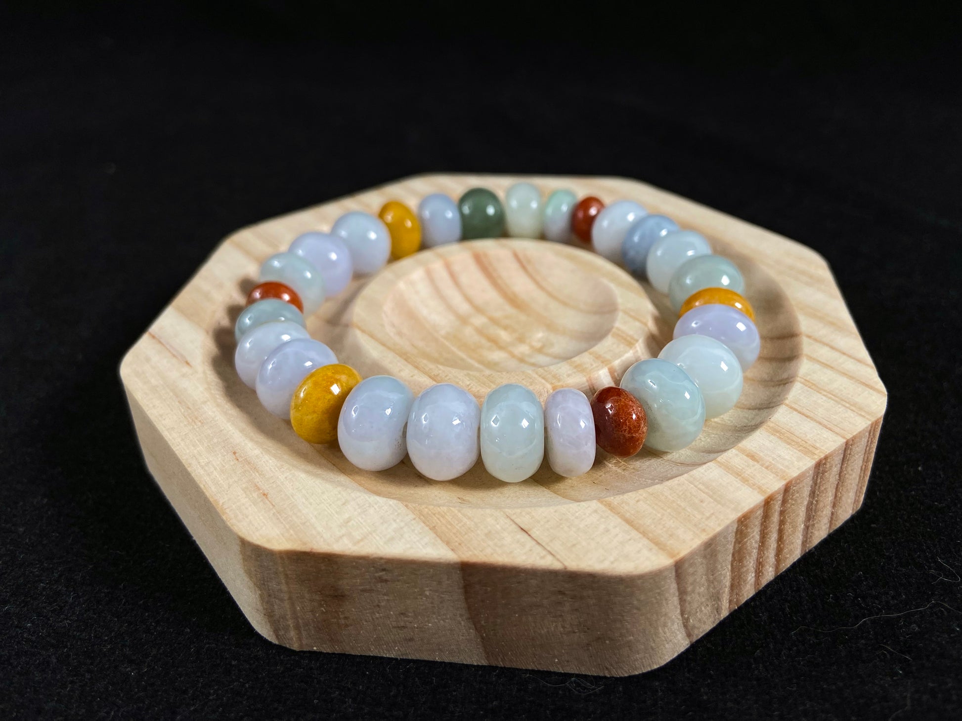 A strand of irregular abacus-shaped jade beads in creamy white, forest green, reddish brown, yellow, tan and light green.