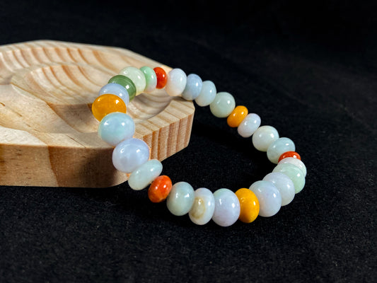 A strand of irregular abacus-shaped jade beads in creamy white, forest green, reddish brown, yellow, tan and light green.