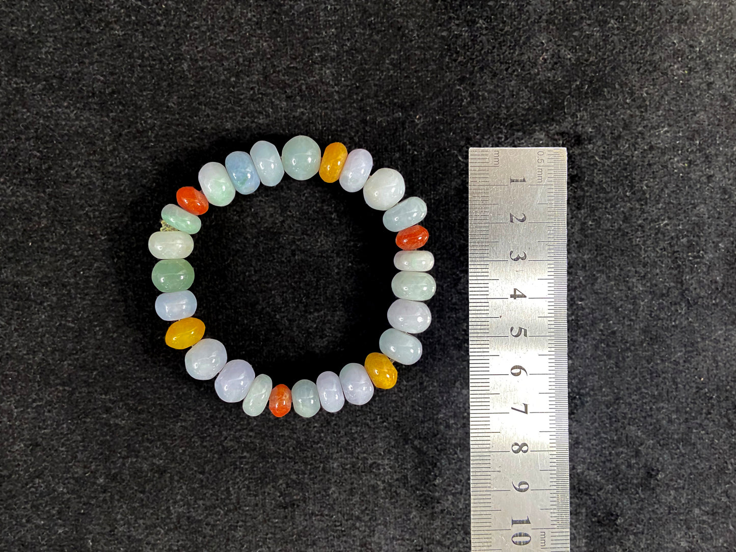 A strand of irregular abacus-shaped jade beads in creamy white, forest green, reddish brown, yellow, tan and light green.