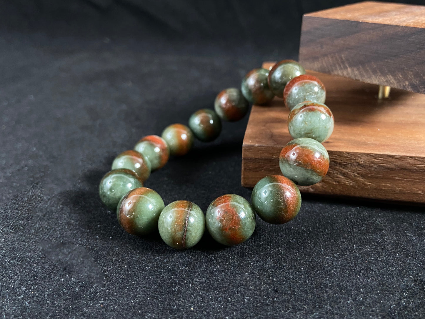 Forest green jade beads with vibrant vermilion accents.