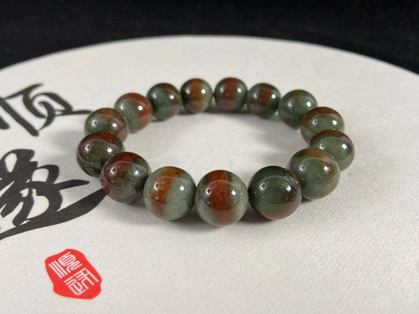Forest green jade beads with vibrant vermilion accents.
