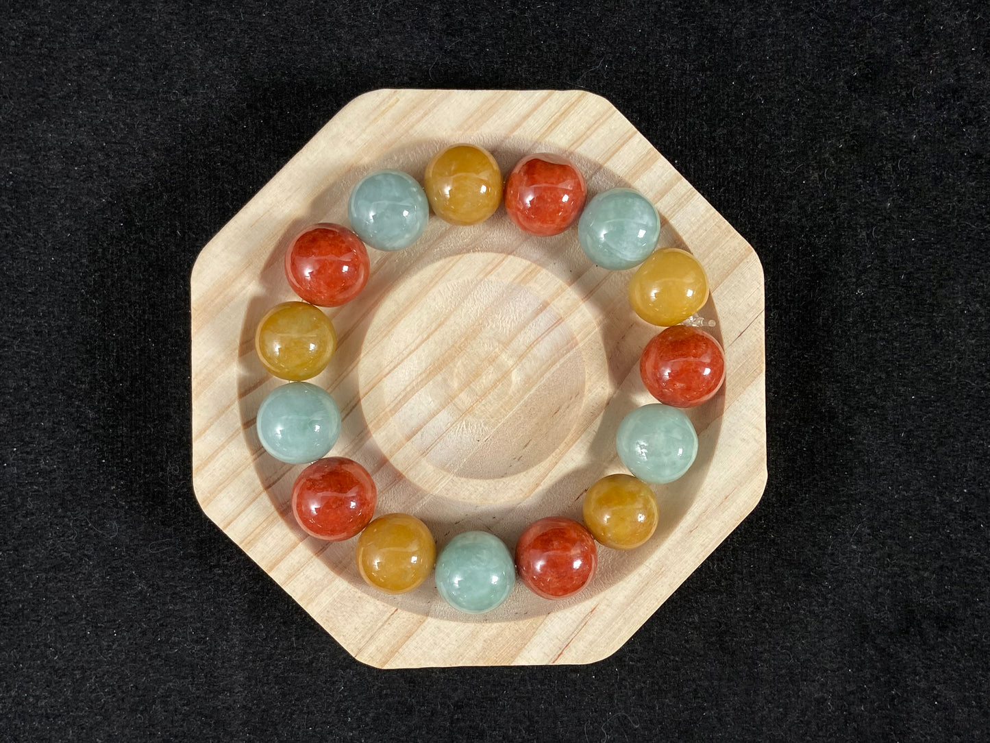 A jade bead strand blending burgundy, yellow, and pale greenish white tones.