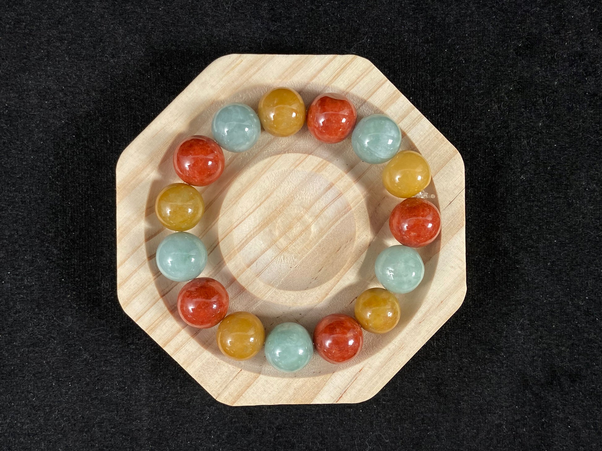 A jade bead strand blending burgundy, yellow, and pale greenish white tones.