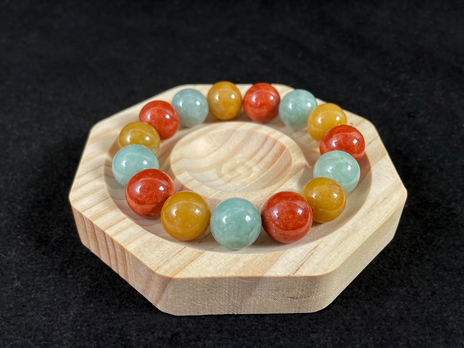 A jade bead strand blending burgundy, yellow, and pale greenish white tones.