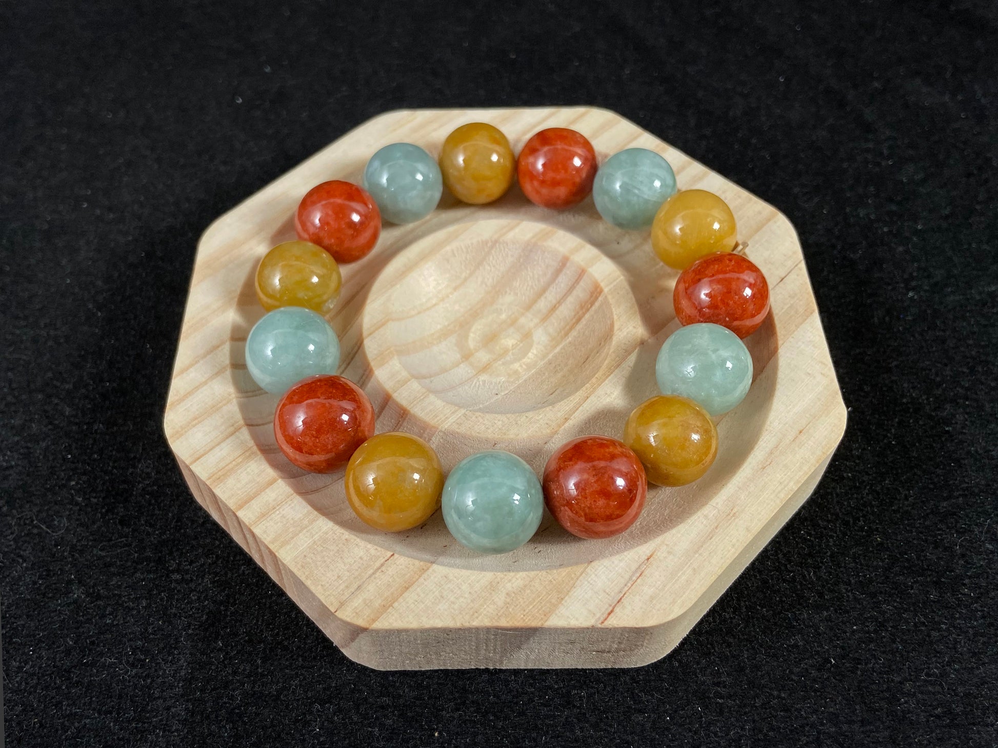 A jade bead strand blending burgundy, yellow, and pale greenish white tones.