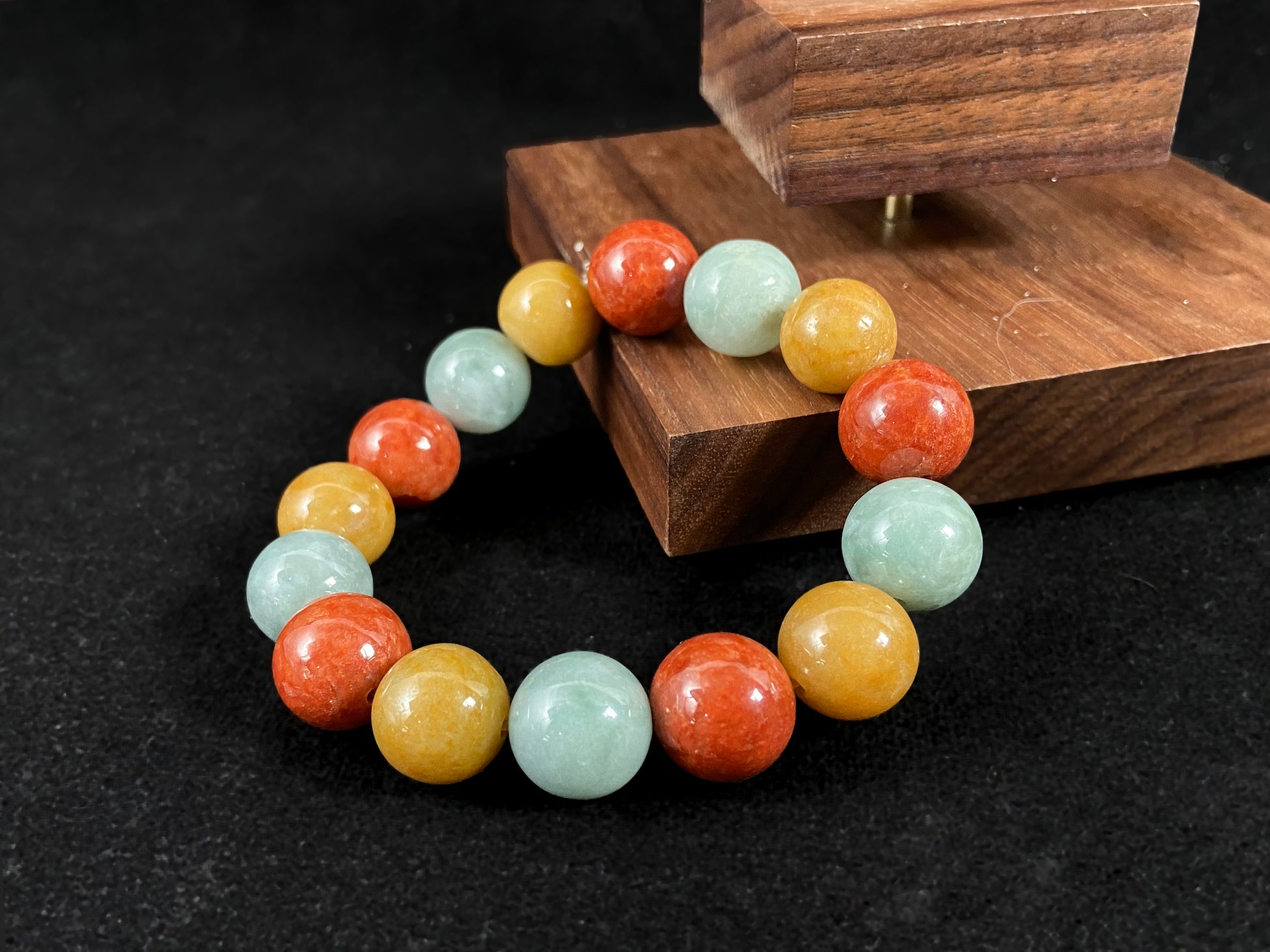 A jade bead strand blending burgundy, yellow, and pale greenish white tones.