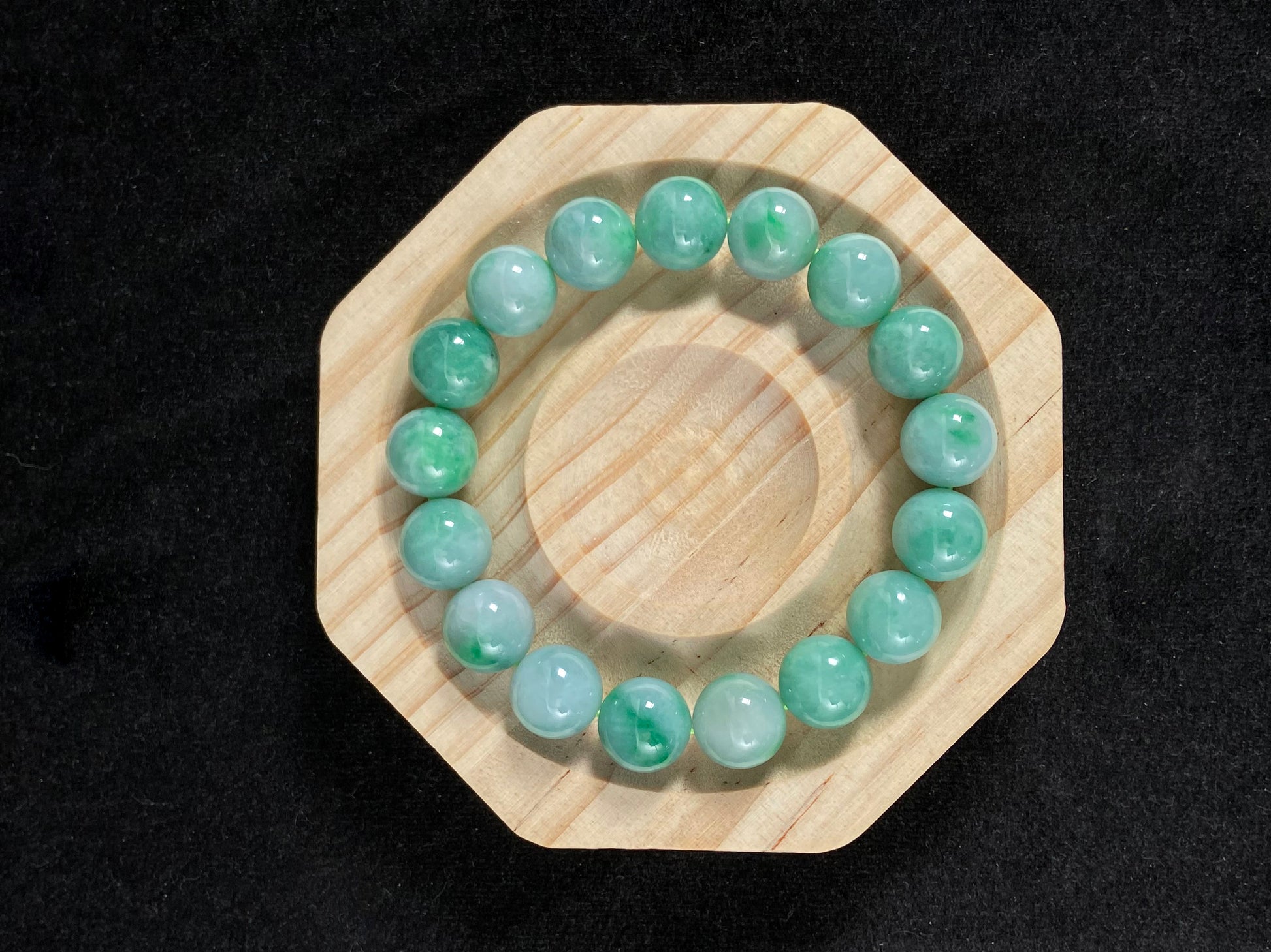 A jade bead strand featuring unique white green tones in varying shades.