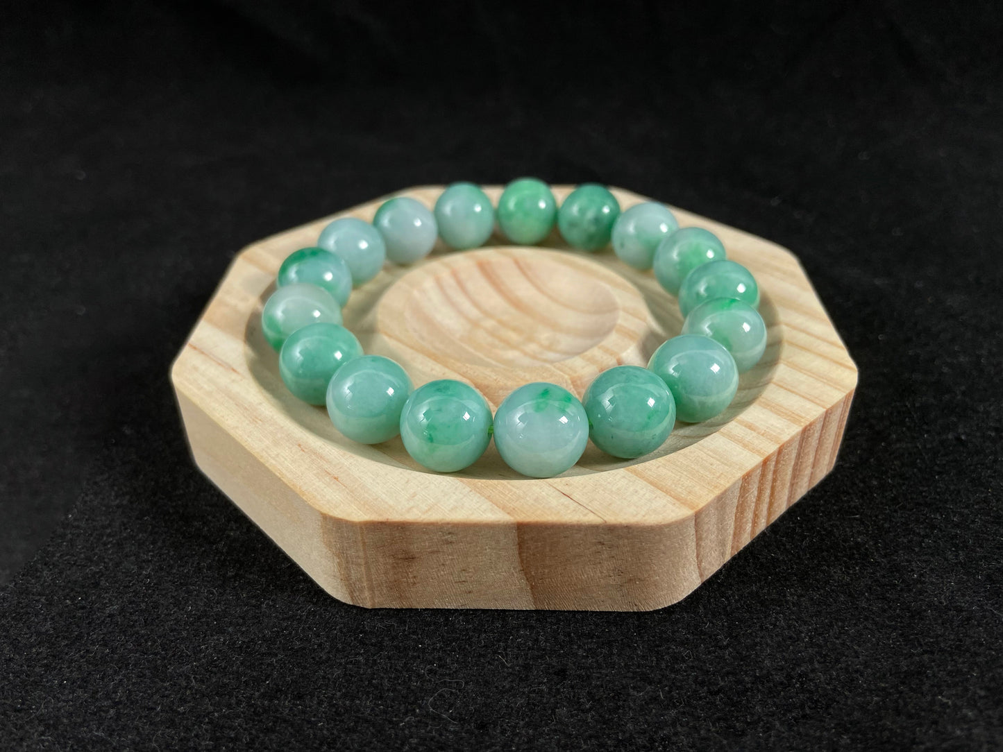 A jade bead strand featuring unique white green tones in varying shades.