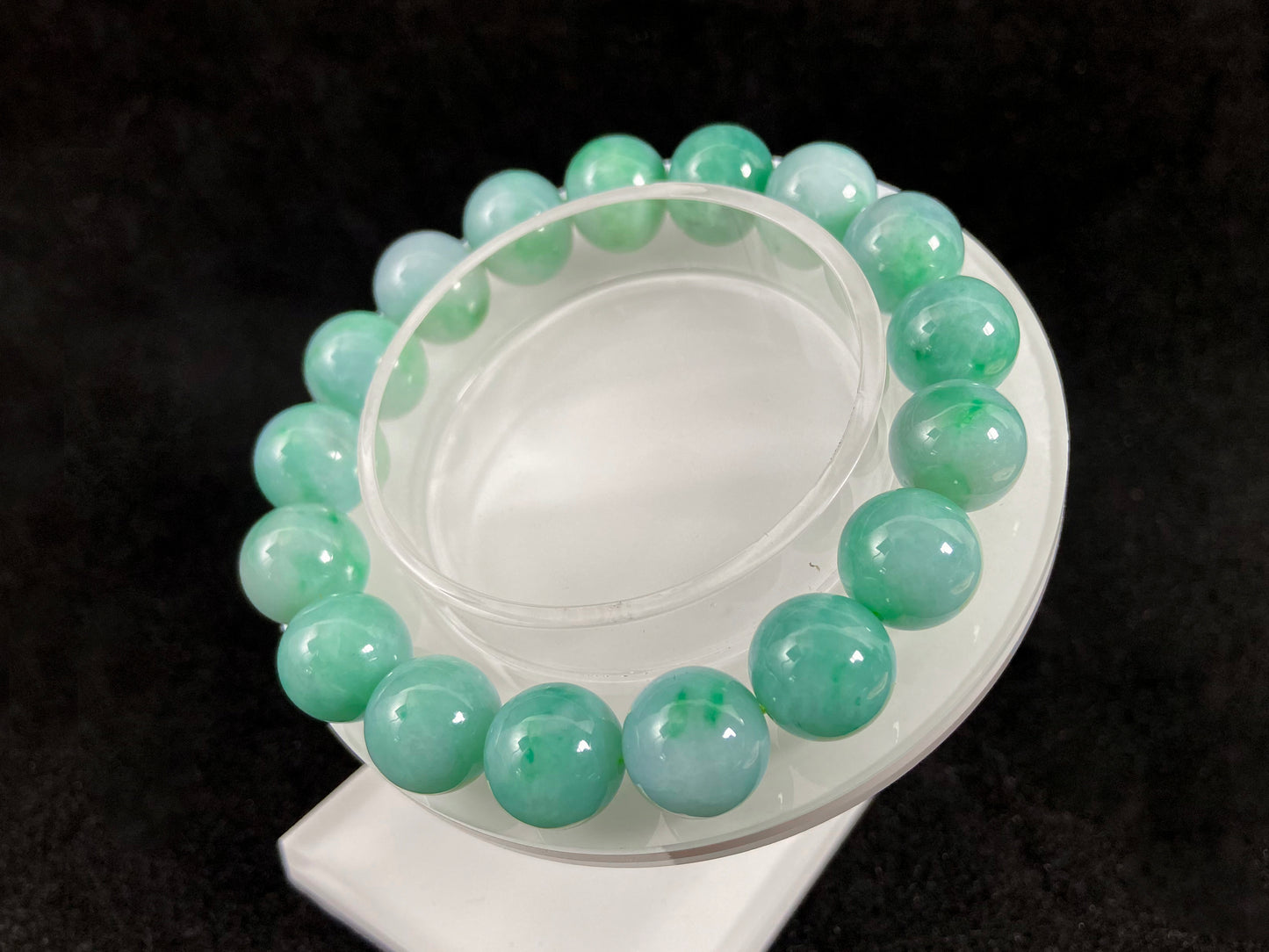 A jade bead strand featuring unique white green tones in varying shades.