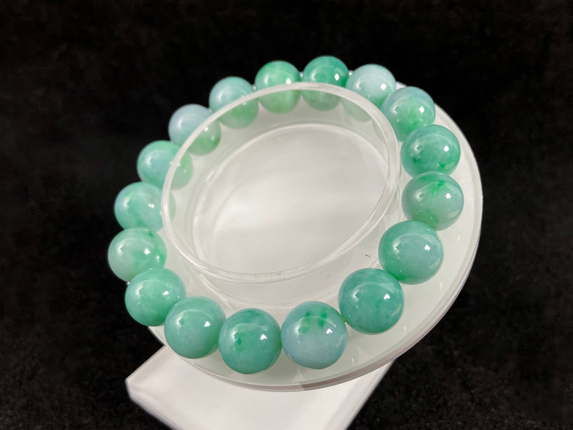 A jade bead strand featuring unique white green tones in varying shades.