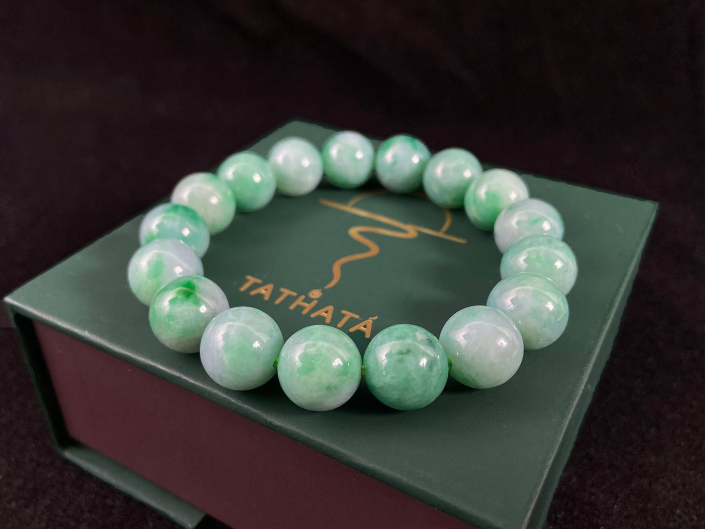 A jade bead strand featuring unique white green tones in varying shades.