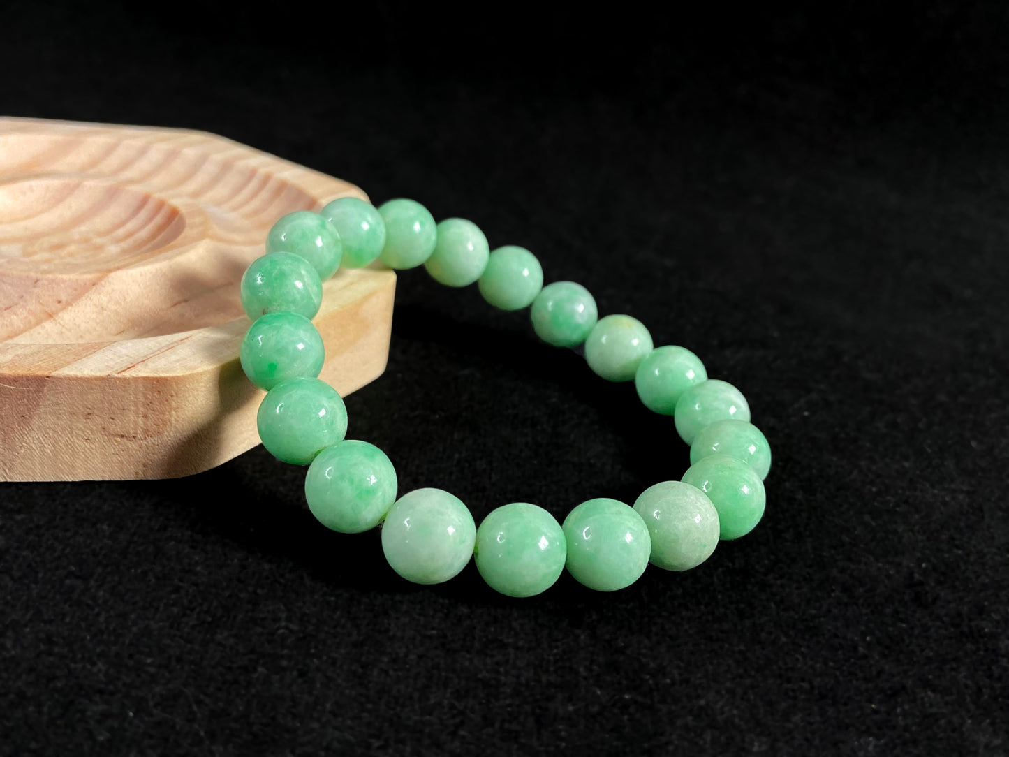A jade bead strand featuring apple green tones.