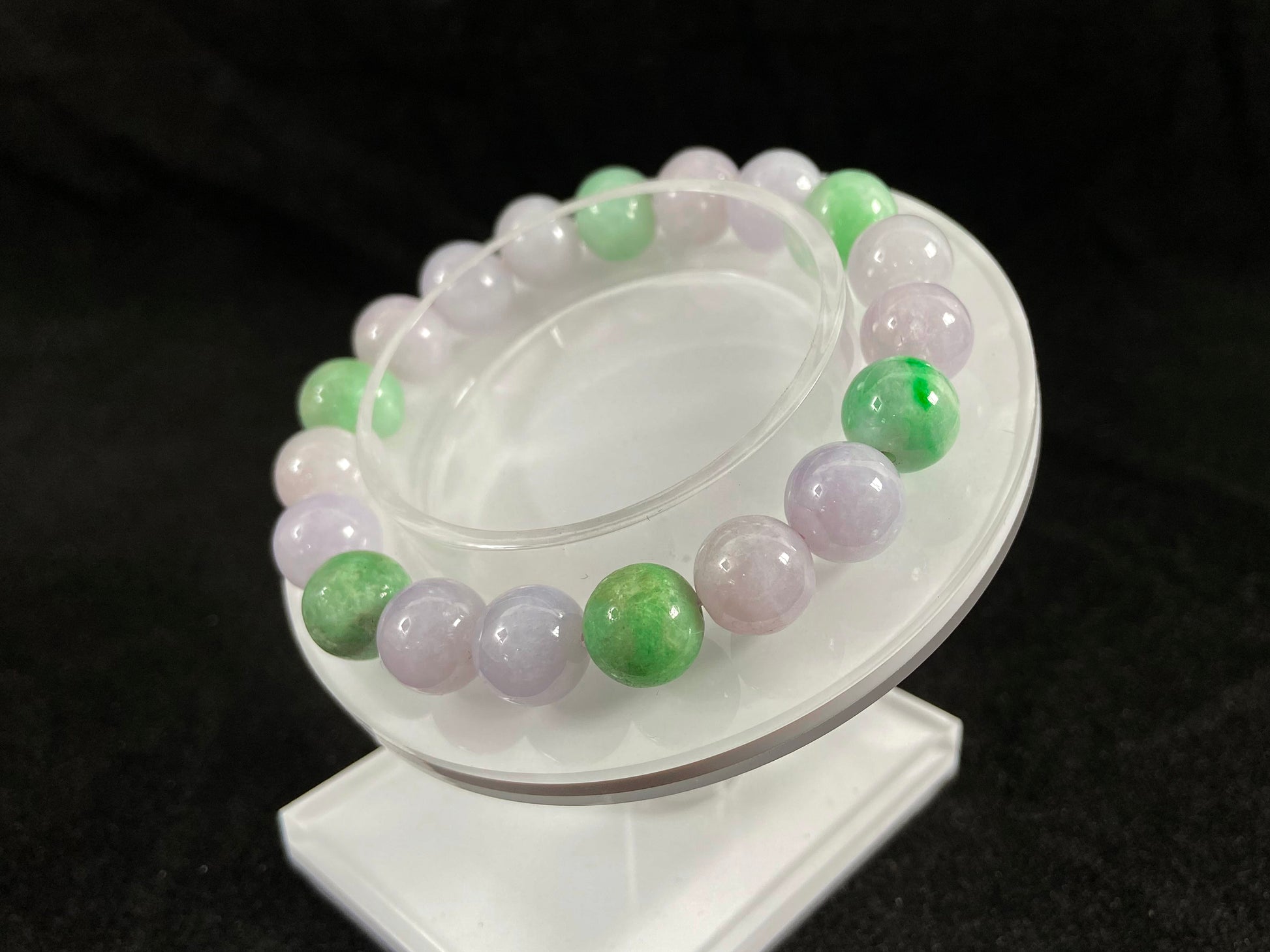 A strand of uniform pale lavender-white jade beads featuring six strategically placed icy green white accent beads.