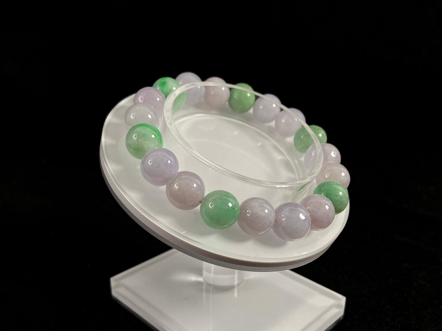 A strand of uniform pale lavender-white jade beads featuring six strategically placed icy green white accent beads.