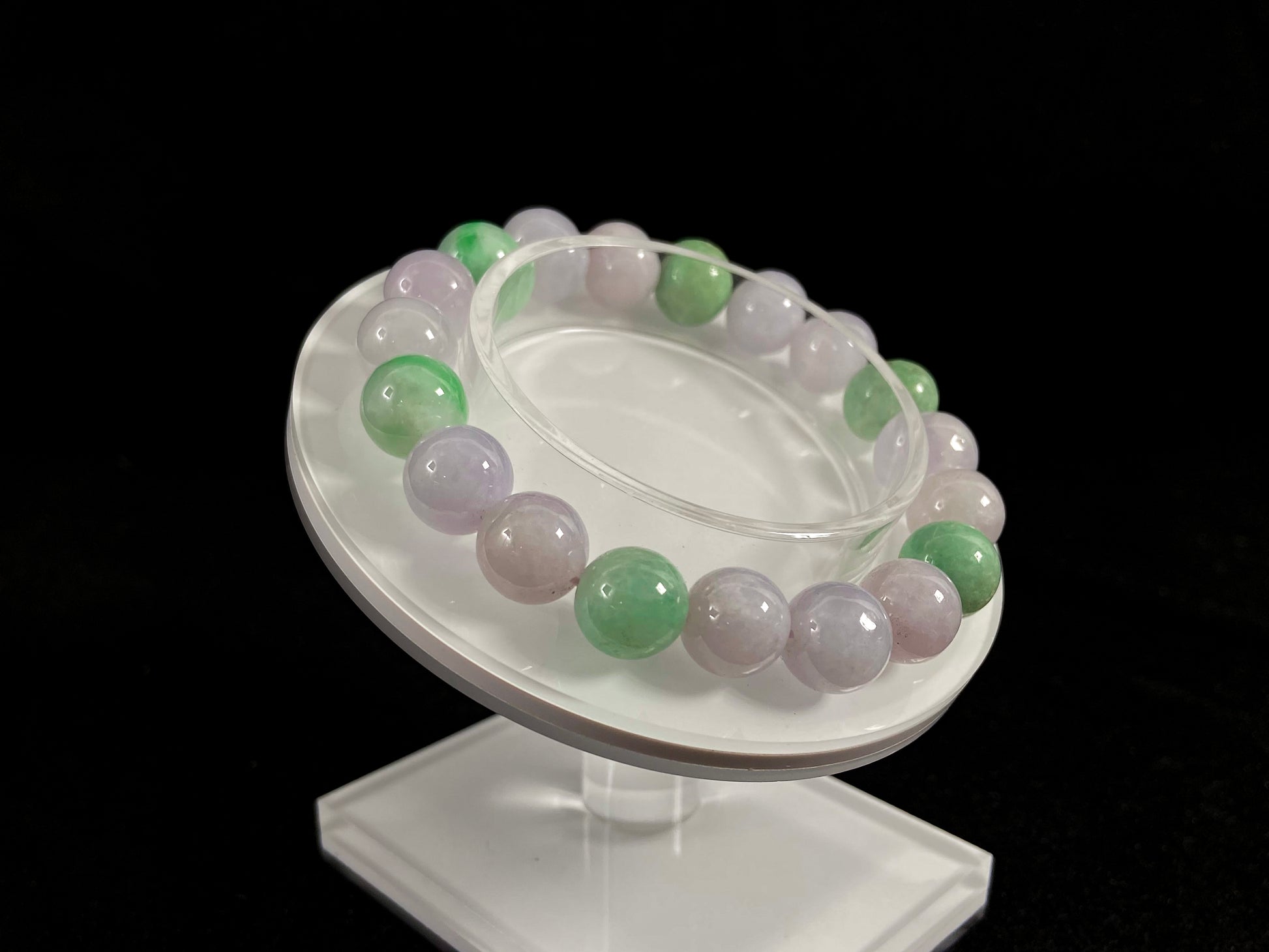 A strand of uniform pale lavender-white jade beads featuring six strategically placed icy green white accent beads.