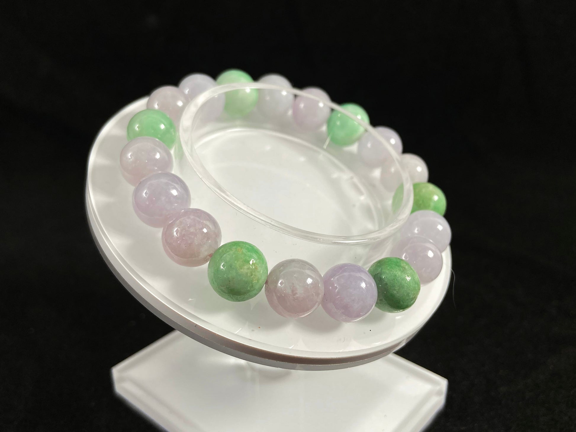 A strand of uniform pale lavender-white jade beads featuring six strategically placed icy green white accent beads.
