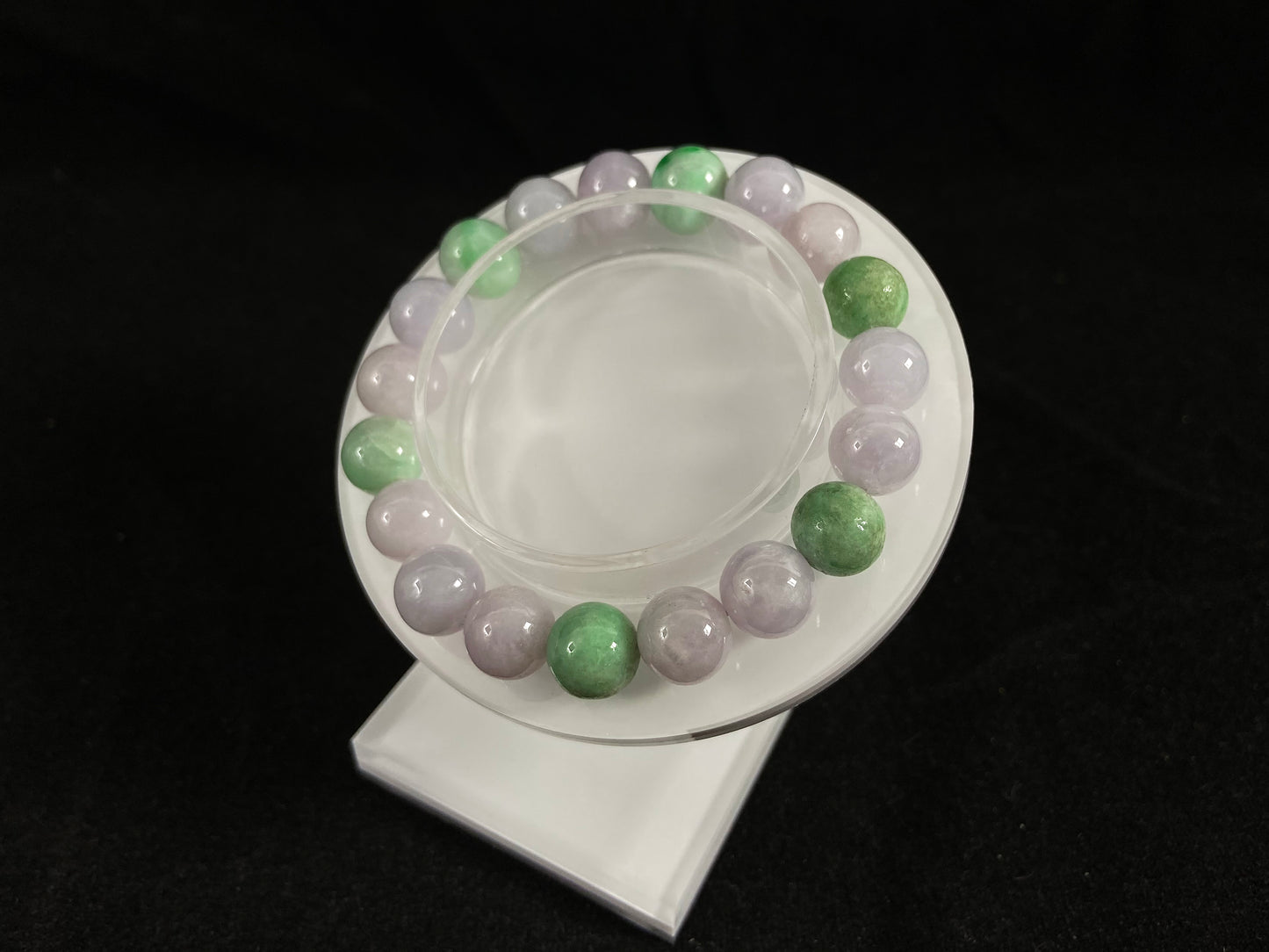 A strand of uniform pale lavender-white jade beads featuring six strategically placed icy green white accent beads.