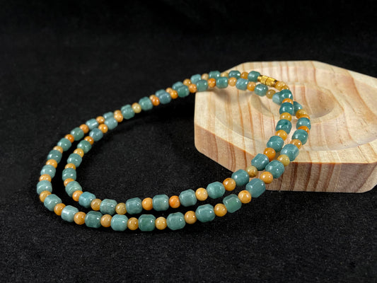 A jade strand combining cyan cylinder beads and yellow round beads.
