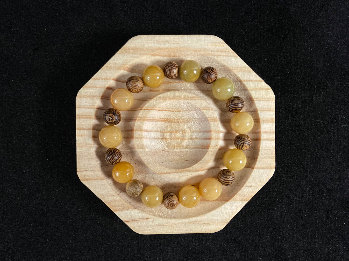A jade and sandalwood bead strand featuring alternating yellow jade and wooden beads.