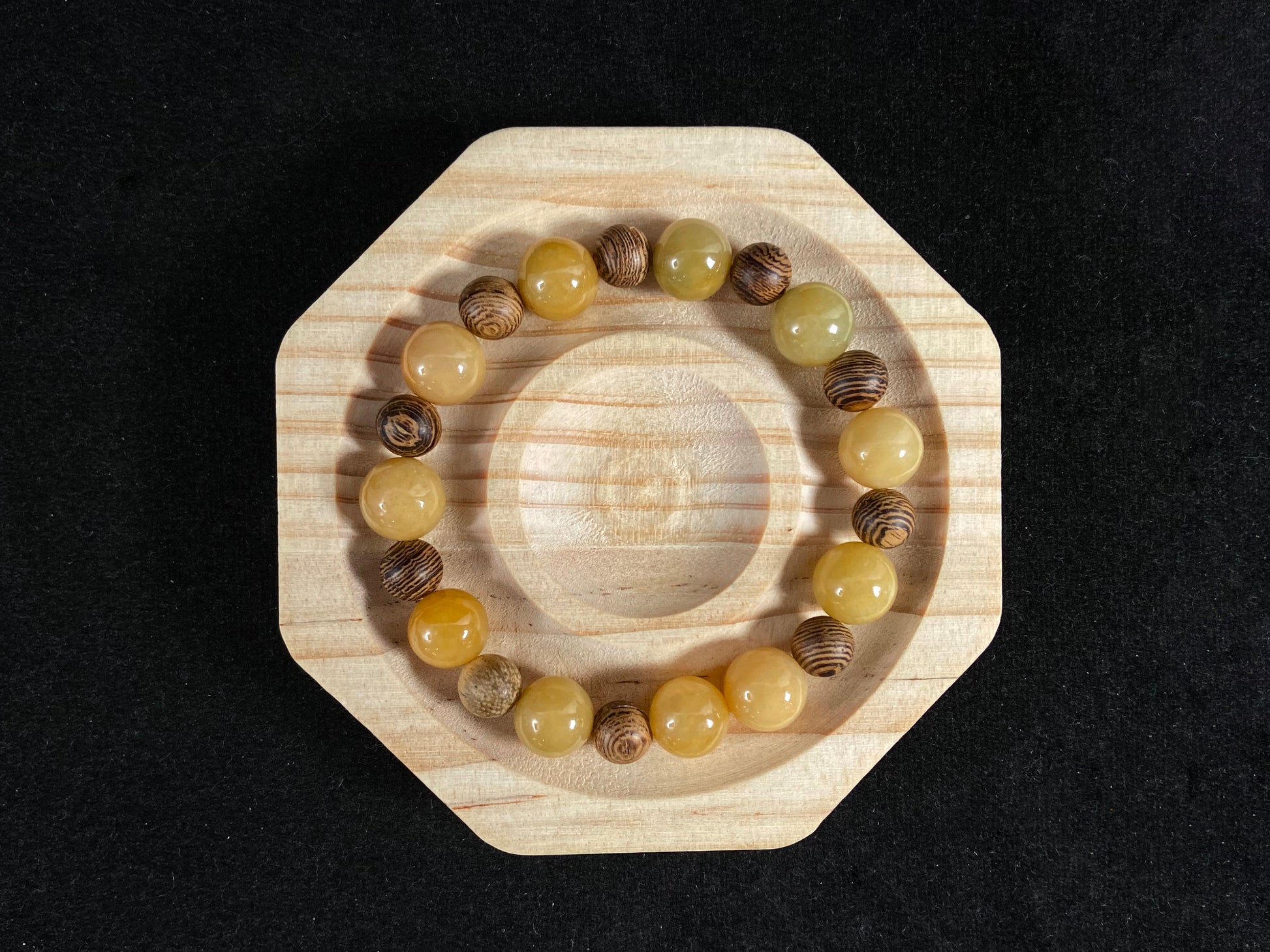 A jade and sandalwood bead strand featuring alternating yellow jade and wooden beads.