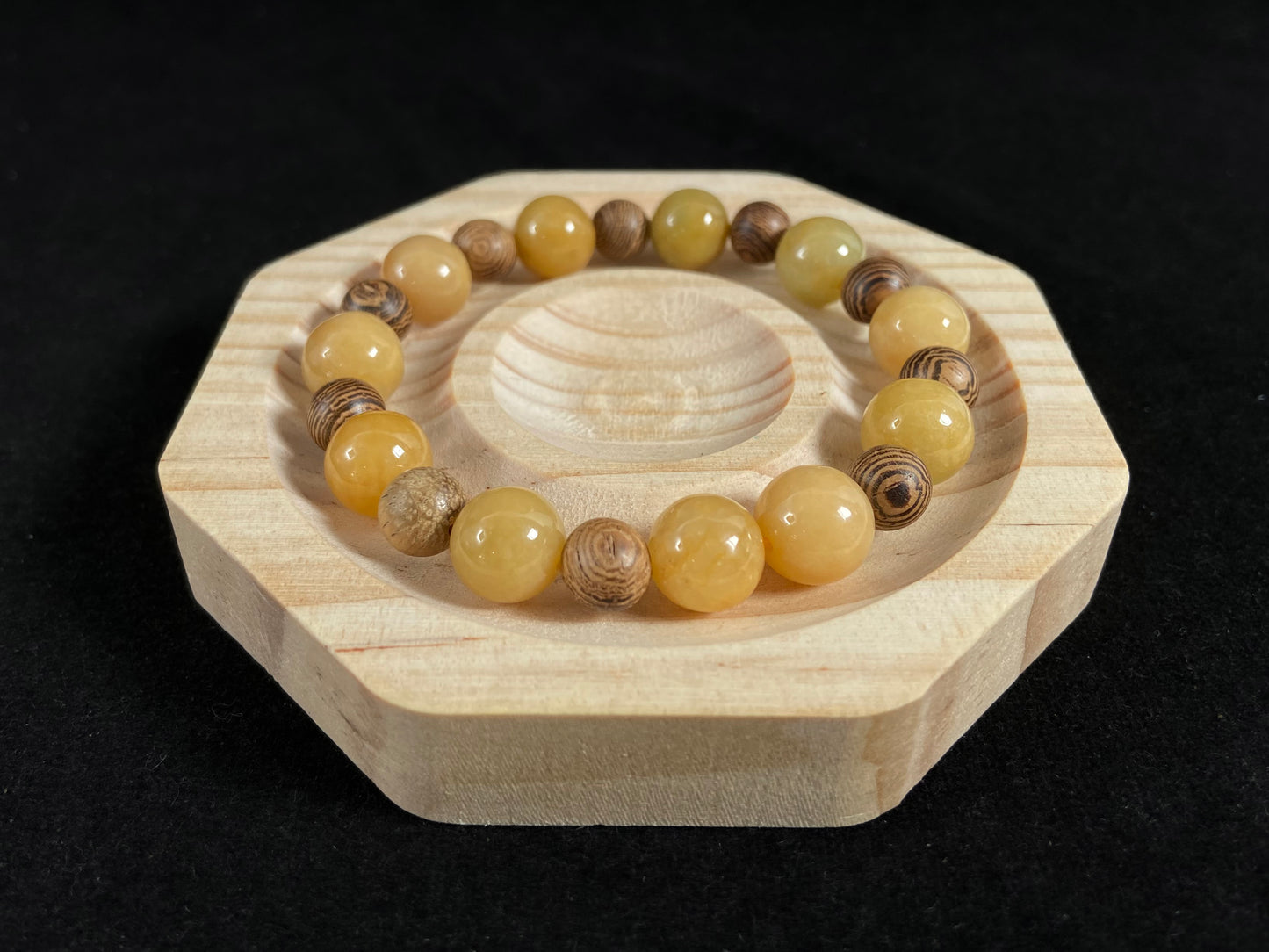A jade and sandalwood bead strand featuring alternating yellow jade and wooden beads.
