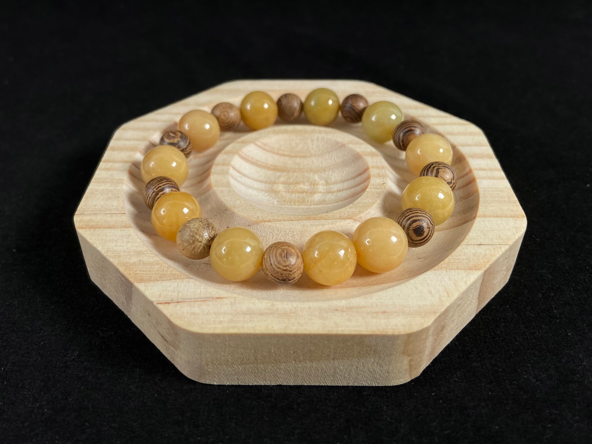 A jade and sandalwood bead strand featuring alternating yellow jade and wooden beads.