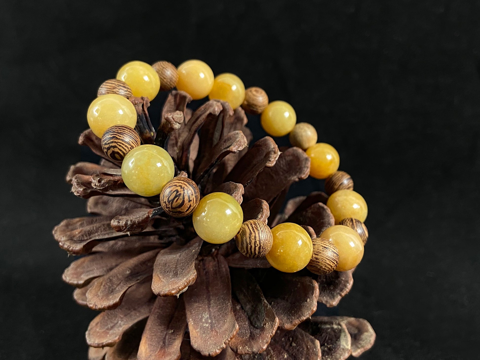 A jade and sandalwood bead strand featuring alternating yellow jade and wooden beads.