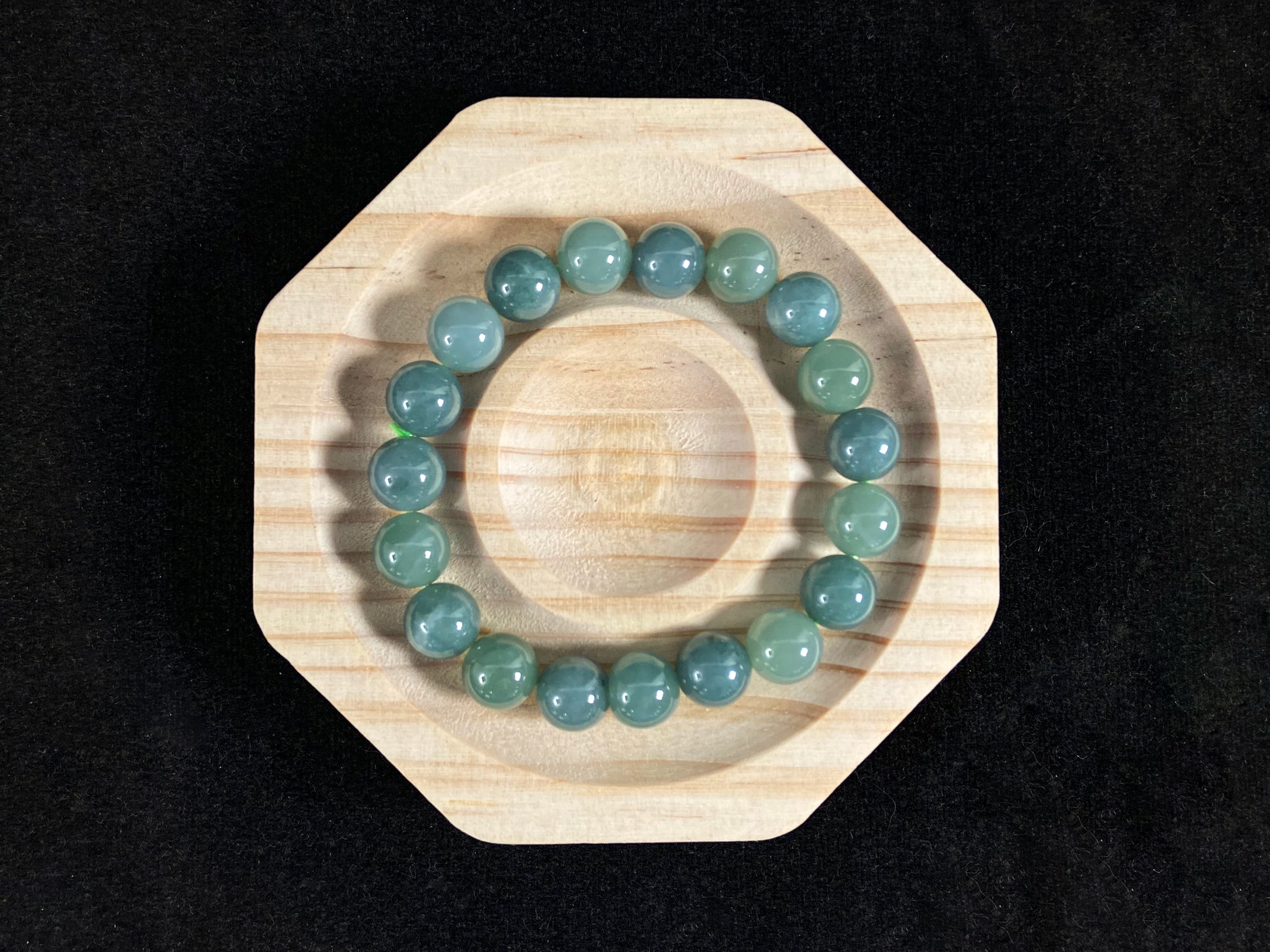 This jadeite bead strand has uniformly sized beads, including translucent pale green ones and opaque green ones.