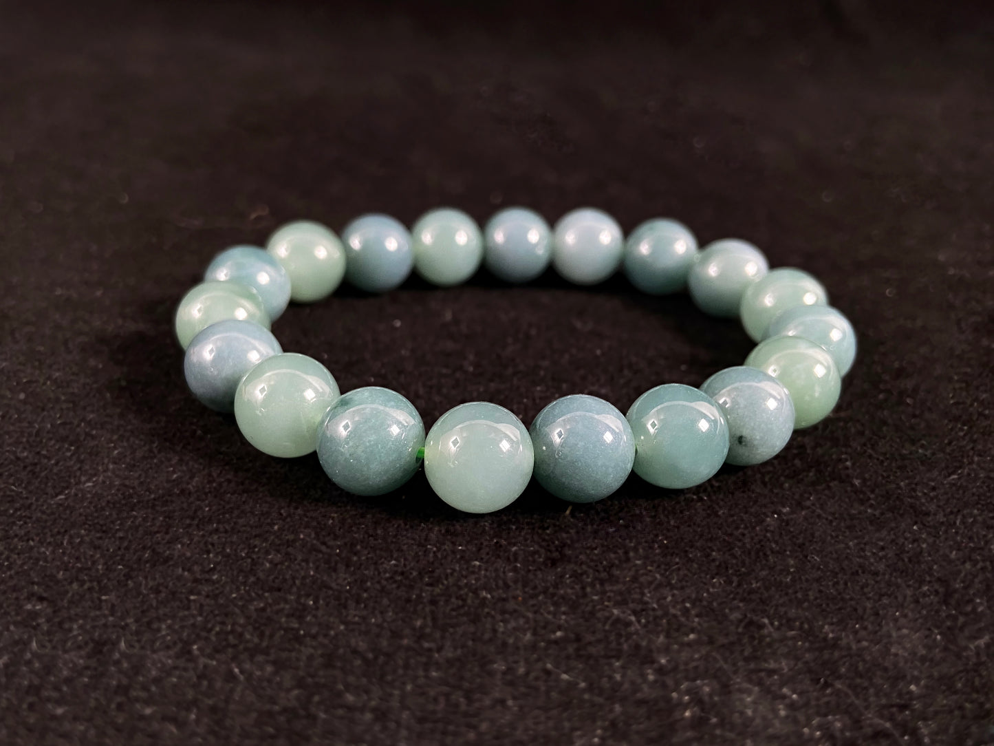This jadeite bead strand has uniformly sized beads, including translucent pale green ones and opaque green ones.