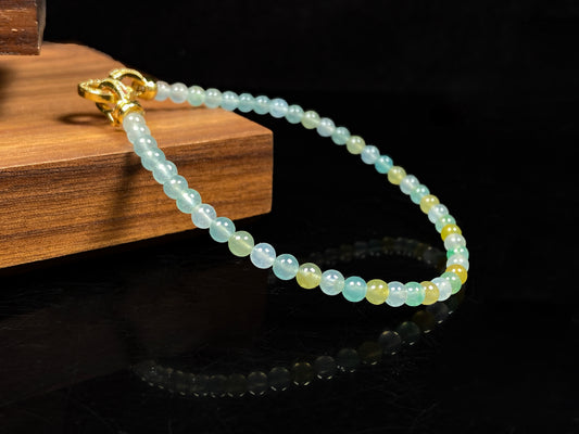 A jadeite beaded bracelet interwoven with gradient light green, lemon yellow and icy white.