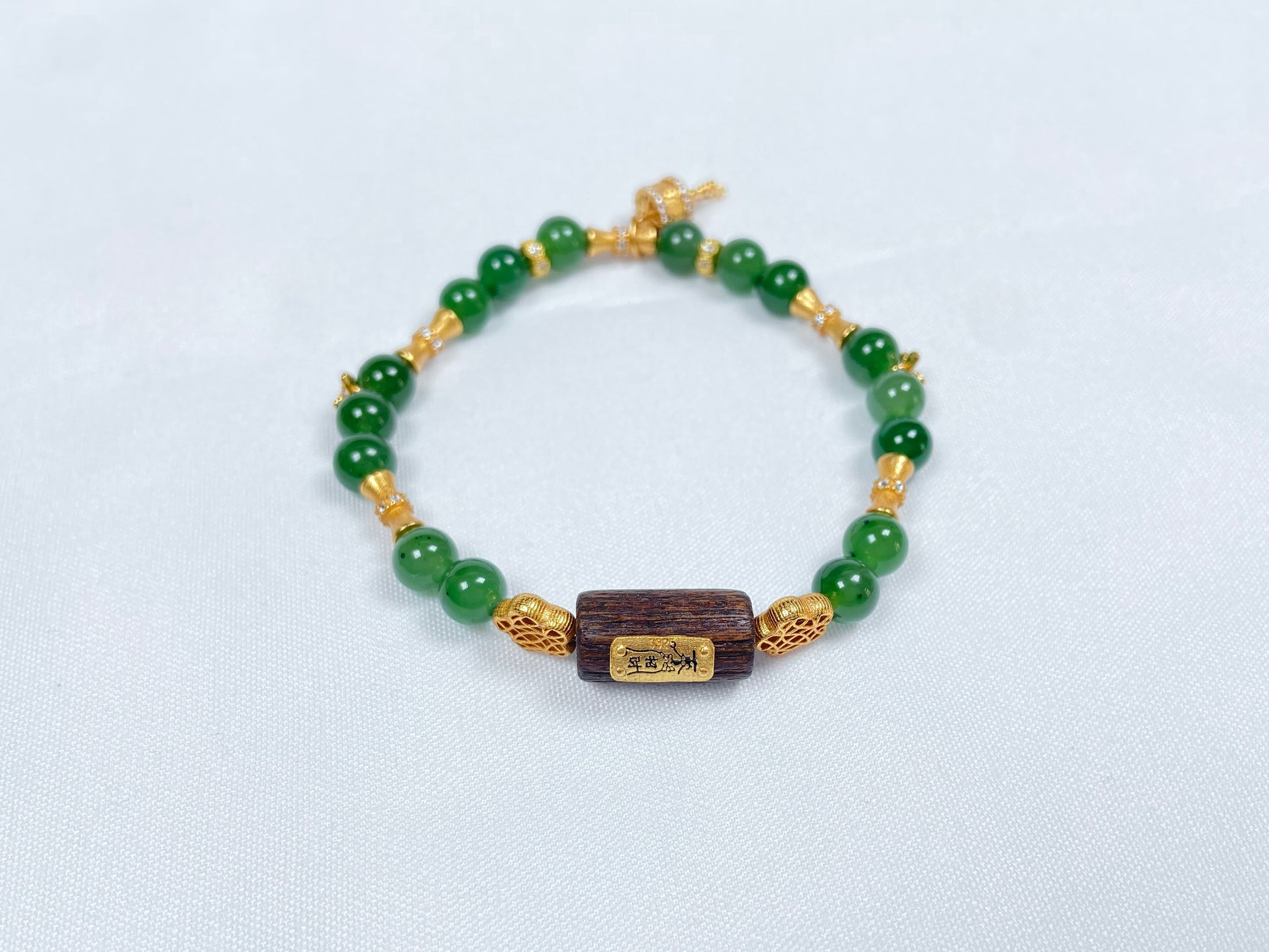 A green Hetian Jade, agarwood, and Wuji jadeite silver bracelet.