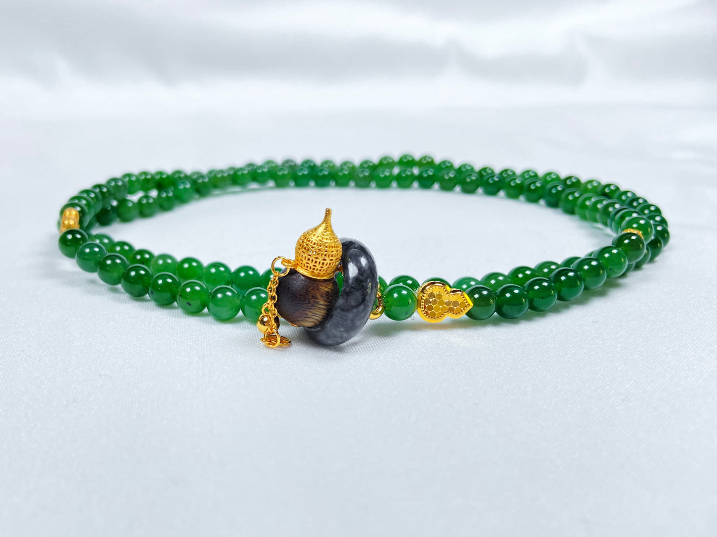 A green Hetian Jade, agarwood, and Wuji jadeite silver necklace.