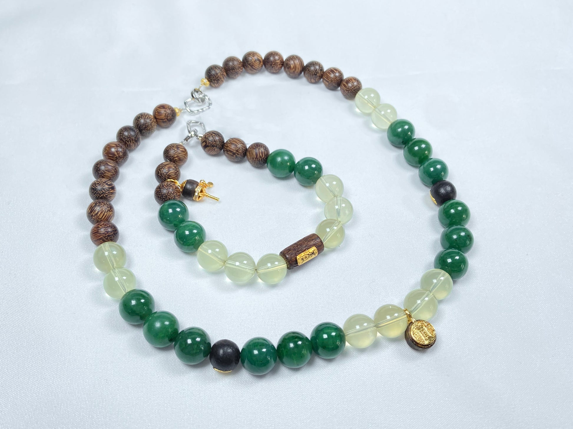 A necklace and bracelet crafted from brown agarwood, green Hetian jade and yellow citrine beads.