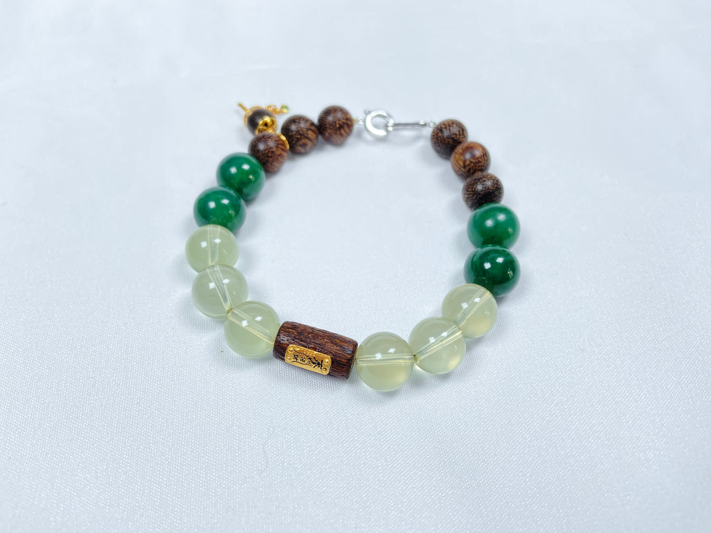 A bracelet crafted from brown agarwood, green Hetian jade and yellow citrine beads.