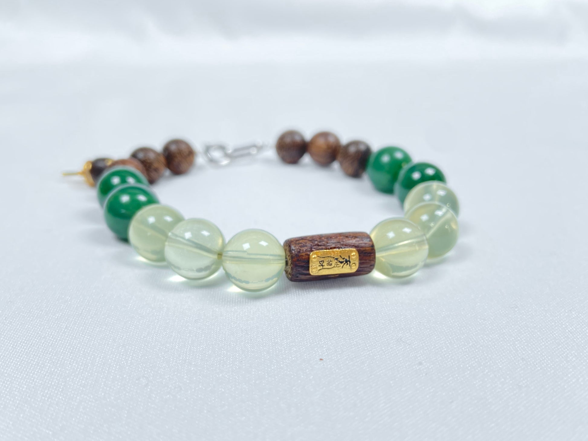 A bracelet crafted from brown agarwood, green Hetian jade and yellow citrine beads.