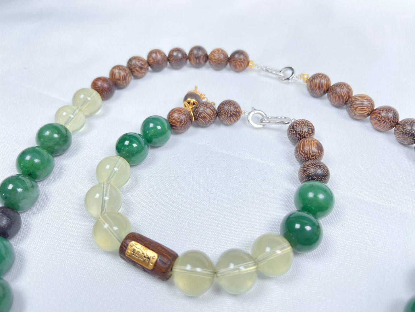A necklace and bracelet crafted from brown agarwood, green Hetian jade and yellow citrine beads.
