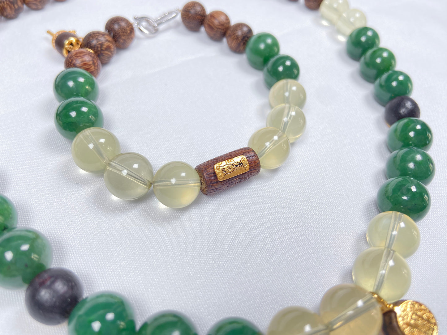 A bracelet crafted from brown agarwood, green Hetian jade and yellow citrine beads.