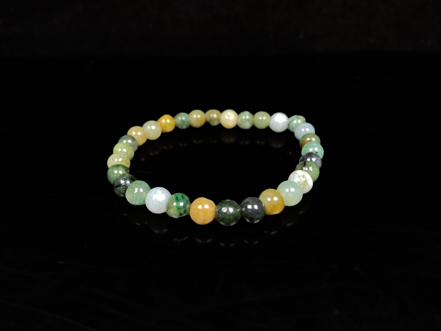 A jadeite beaded bracelets is made of mixed green, yellow, gray and black beads.