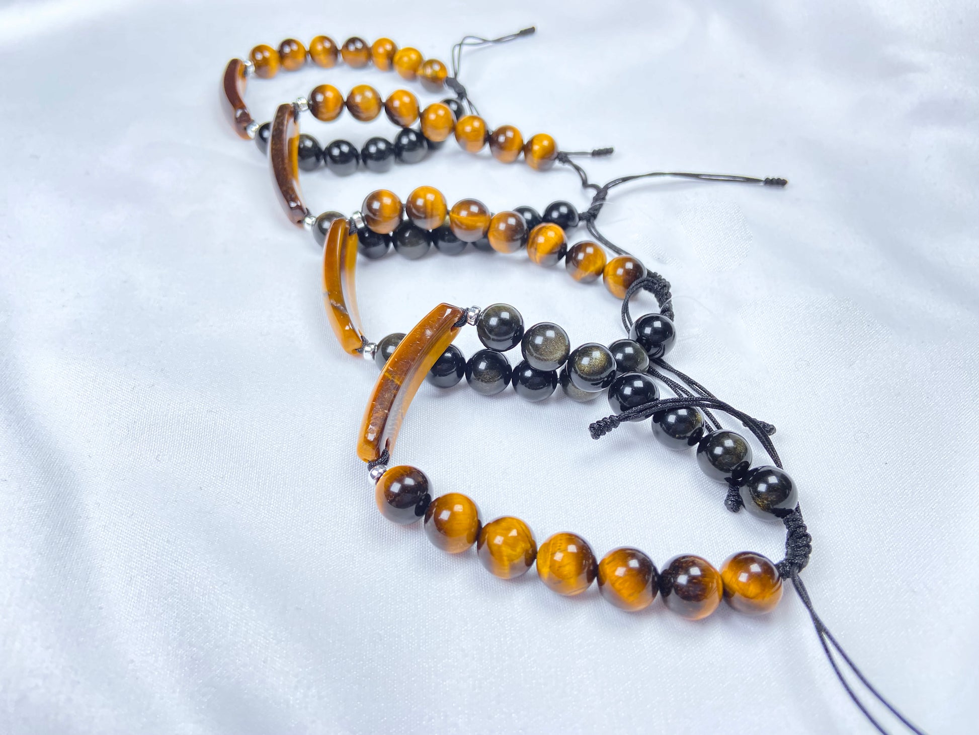 A group of black and gold contrast natural tiger's eye beaded bracelet.