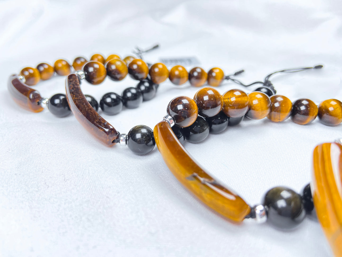 A group of black and gold contrast natural tiger's eye beaded bracelet.
