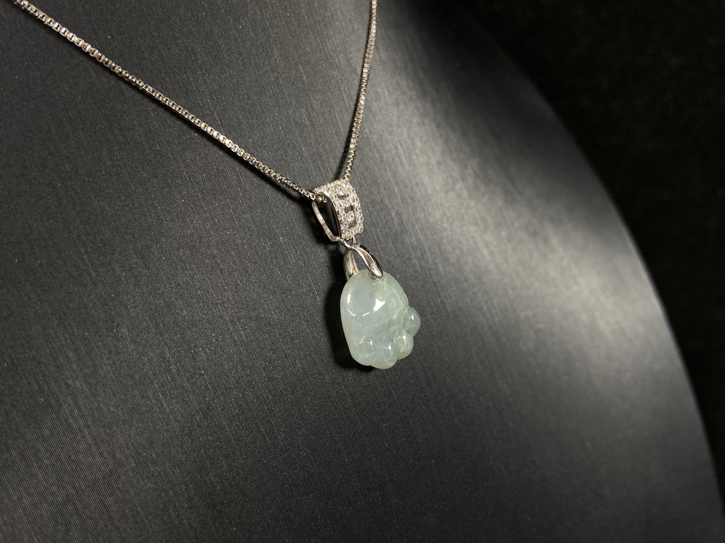 A light green jadeite cat paw pendant.