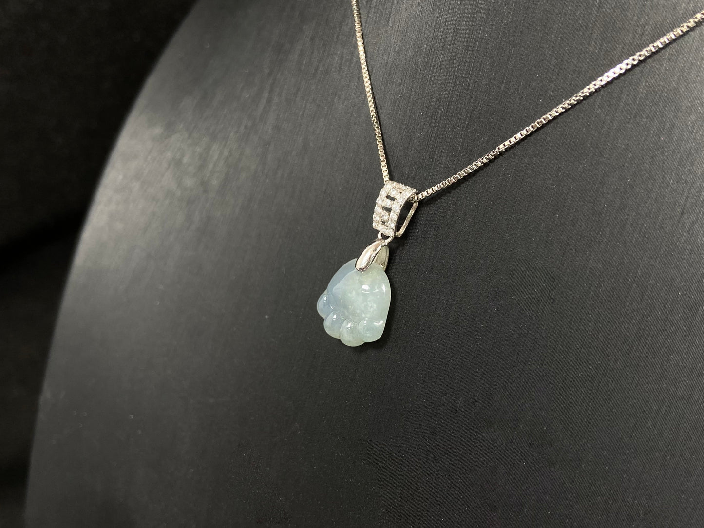 A light green jadeite cat paw pendant.