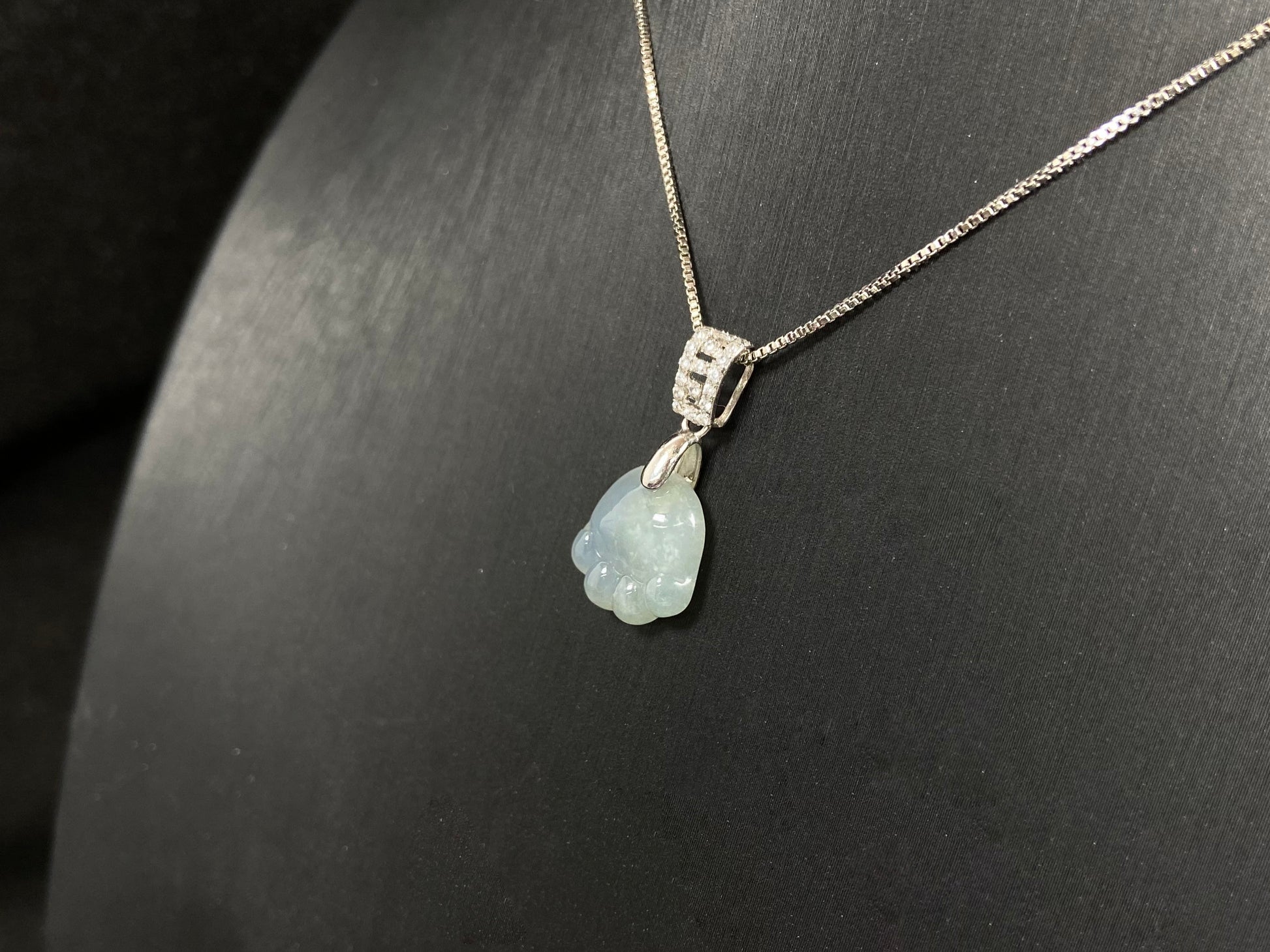 A light green jadeite cat paw pendant.
